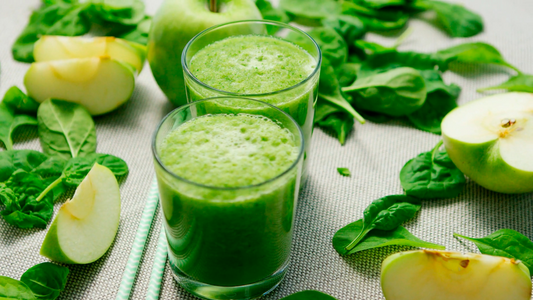 Fresh apple and banana green smoothie with Wellsprout Super Green Powder, served in a glass with chia seeds and almonds
