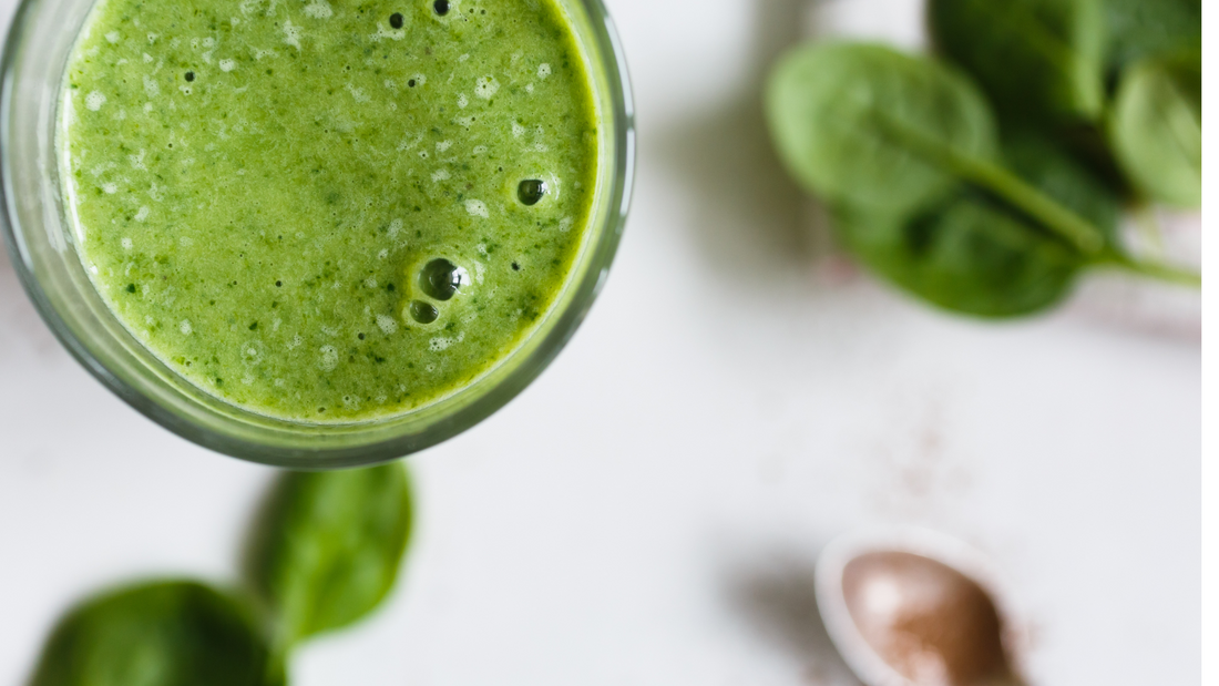 Vibrant spinach and mango green smoothie with Wellsprout Super Green Powder, served in a glass with chia and pumpkin seeds