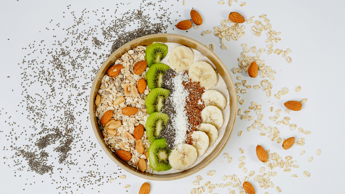 Bowl of green power oats with banana slices, chia seeds, flaxseed, nuts, and Wellsprout Super Green Powder